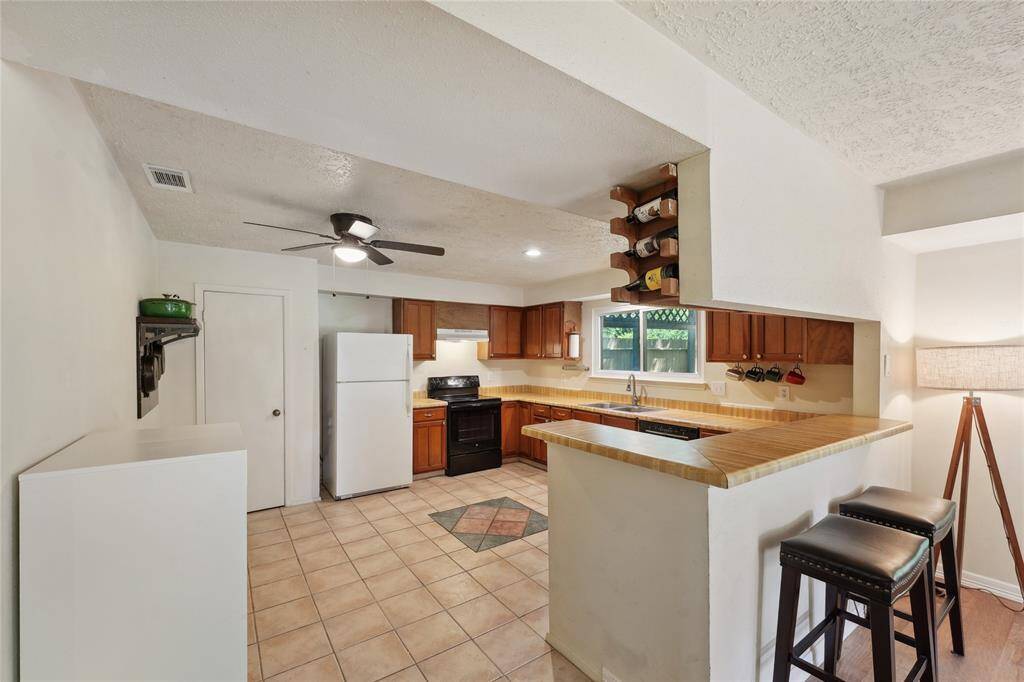 The kitchen offers abundant counter space and plenty of cabinetry for all your storage needs. There’s room for a breakfast table, and a window above the sink provides a charming view into the backyard—perfect for everyday living and casual meals.