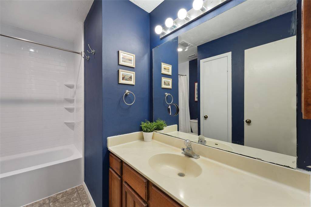 Spacious upstairs game room with rich wood floors, bathed in natural light from a large window. Overlooking the living area below, this space is perfect for movie nights, playtime, or a cozy second lounge