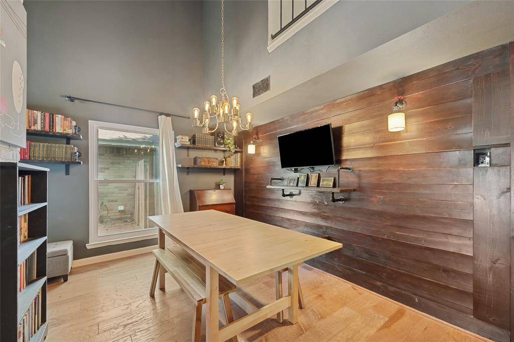 The living room features soaring ceilings, gorgeous wood floors, and a striking two-story brick fireplace that adds warmth and character. This bright, open space is perfect for relaxing or entertaining.