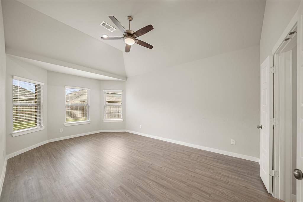 Unwind after a long day in this incredible Primary Bedroom! Featuring a high ceiling with a ceilin fan, windows with privacy blinds, and vinyl floors.