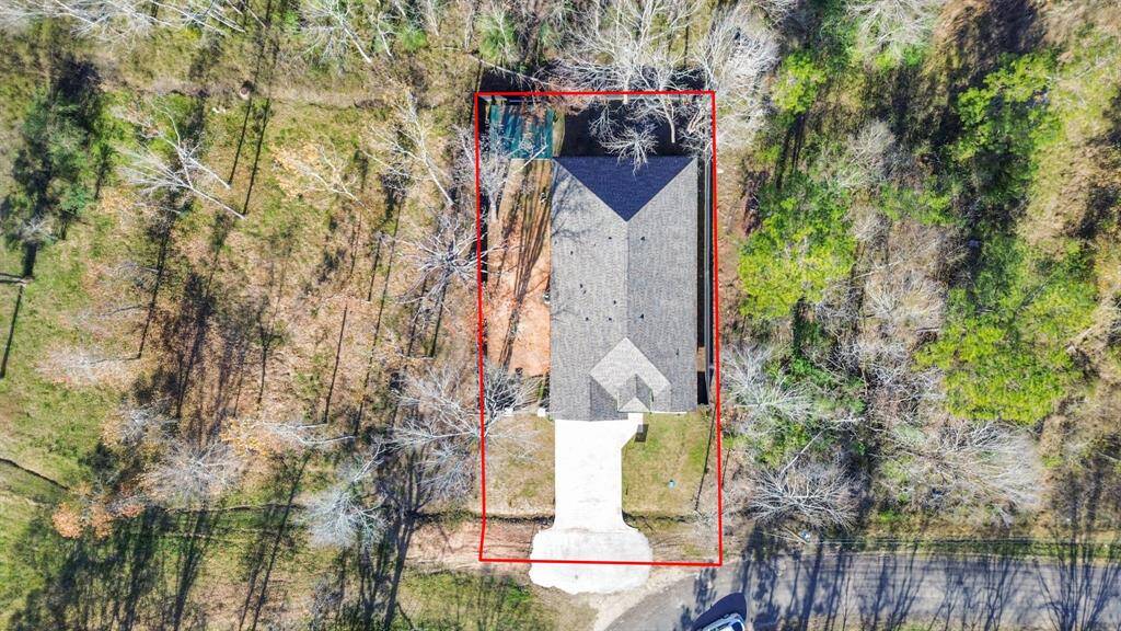 The property is outlined in red, featuring a paved driveway leading to the home.