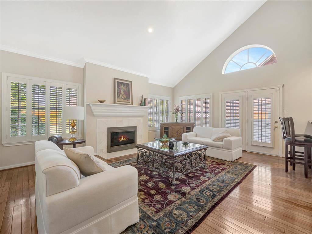 Another view of family room, note gas log fireplace, shutters on all windows and french doors.