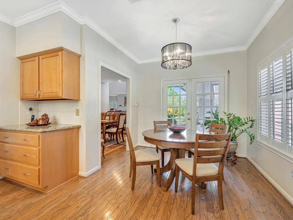 Cute breakfast area, french doors lead to covered patio, shutters over look gated driveway