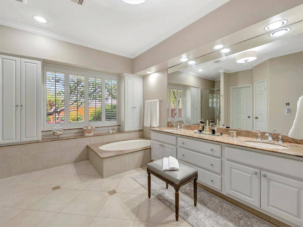 Another view of primary bath, note shutters and extra storage on both sides of window, double sink vanity