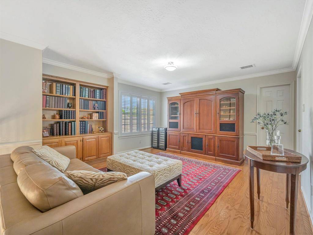 Upstairs gameroom with built in shelves, wood floors and shutters