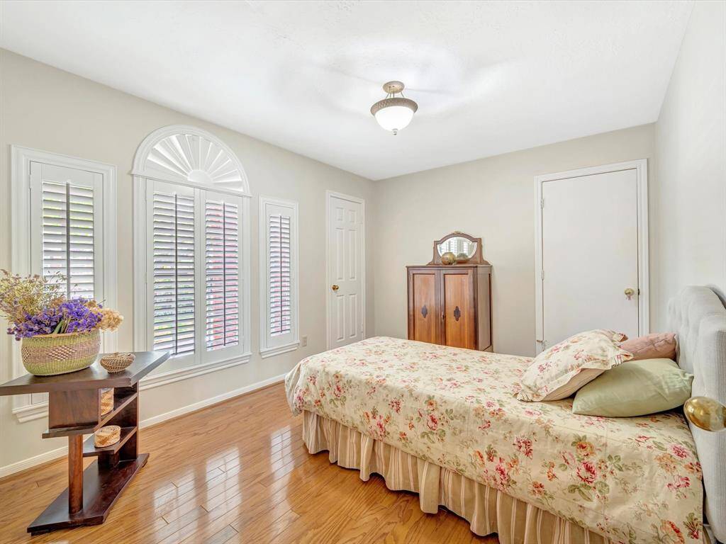 Upstairs guest bedroom 1, offers large walk-in closet and custom shutters, door to right goes to huge walk-in attic, it is a true Texas Basement