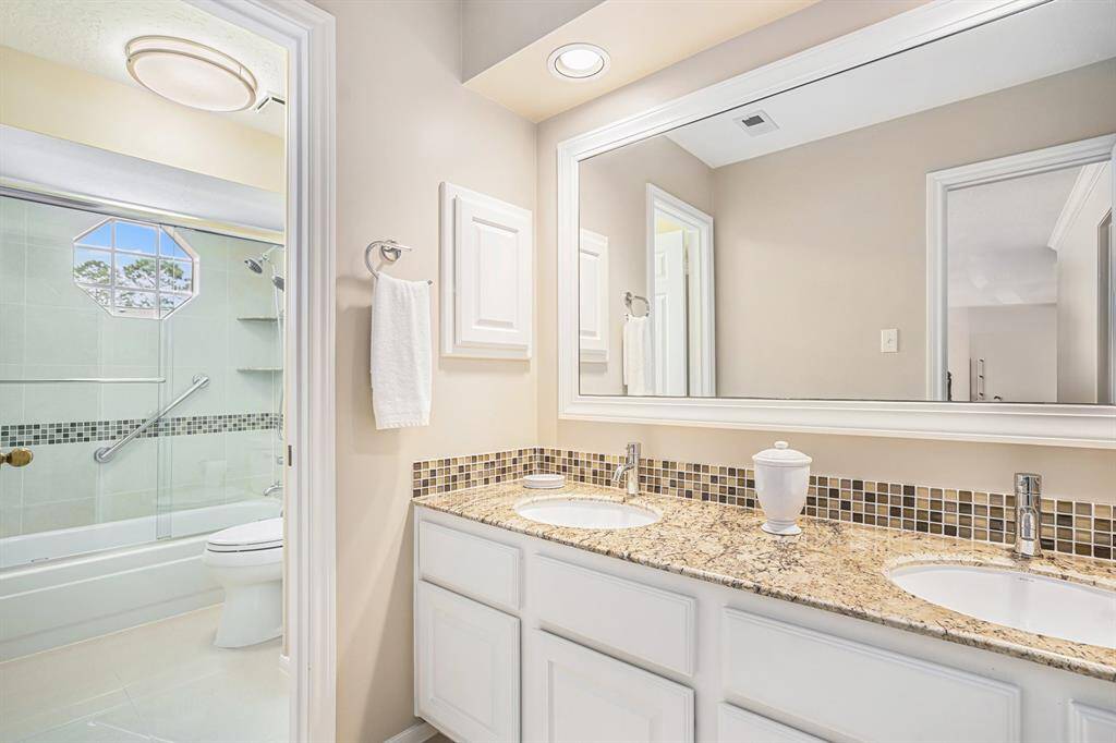 Upstairs guest bathroom, offers double sink vanity and separate tub area for privacy