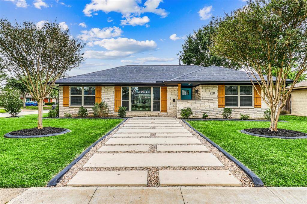 Crisp landscaping, custom stonework, and a sleek modern walkway create striking curb appeal for this beautifully updated Lazybrook gem.