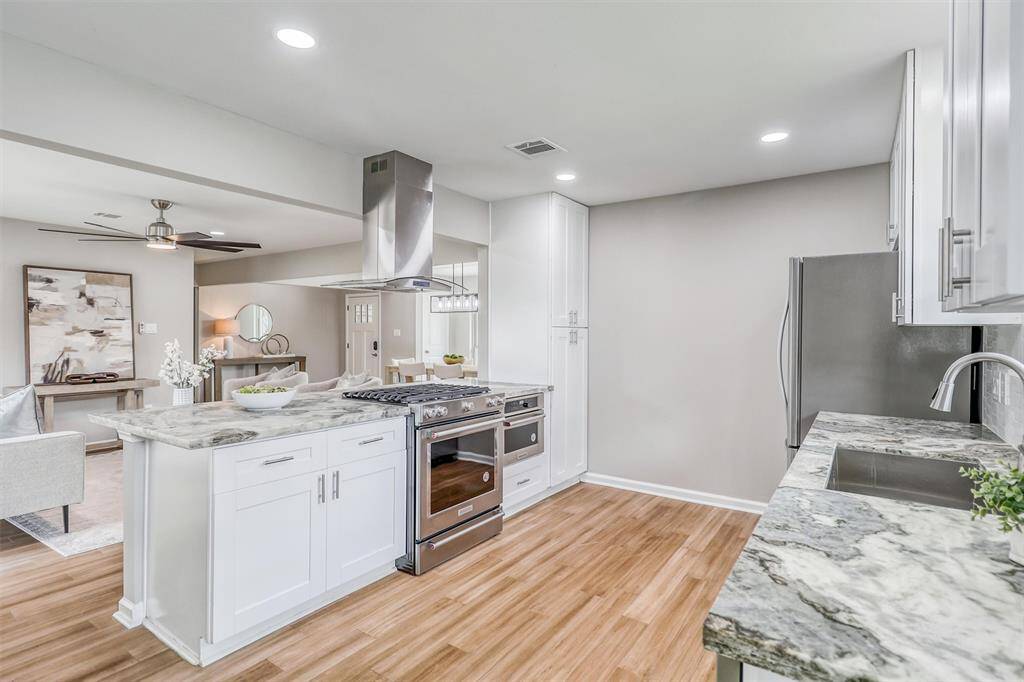 Recessed lighting, a wide-open floor plan, and open sightlines keep this kitchen bright and connected to the rest of the home.