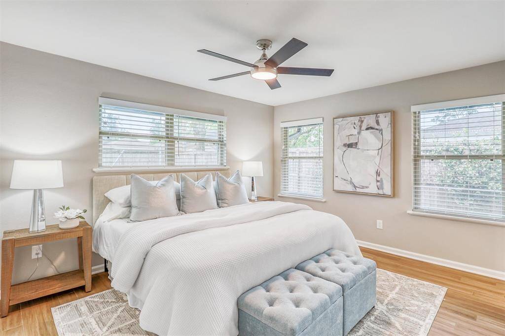 Unwind in this serene primary bedroom, filled with natural light from multiple windows and finished in soft, neutral tones for a calming retreat.
