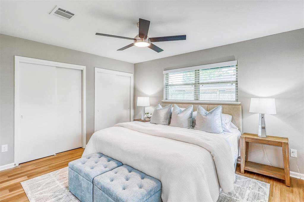 Spacious and airy, the primary bedroom offers dual closets, elegant flooring, and a modern ceiling fan for year-round comfort.