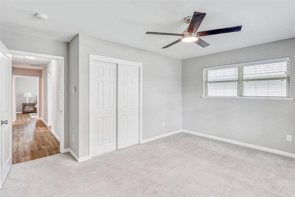 Fresh and airy with soft carpet and neutral tones, the second bedroom includes a generous closet and ample windows for a bright, welcoming atmosphere.