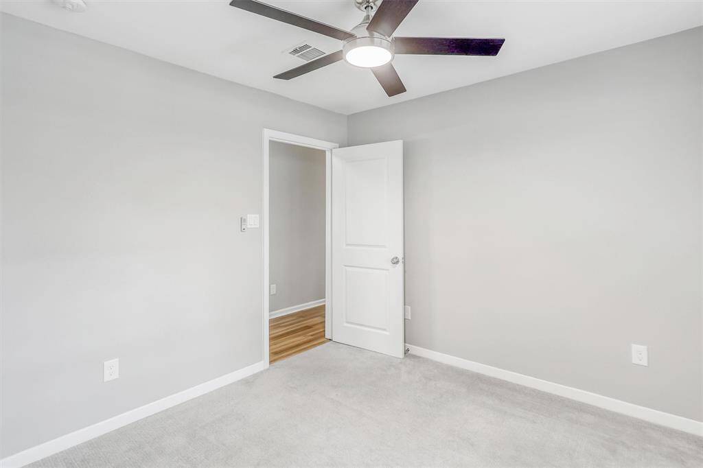 Tucked just off the hallway, this third bedroom is a quiet retreat with a roomy closet, sleek ceiling fan, and updated finishes ready for personalization.