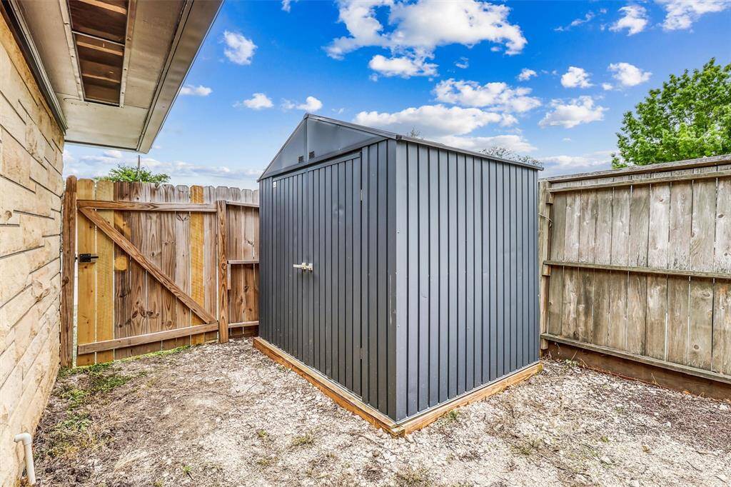 A private fenced side yard includes a convenient storage shed—ideal for keeping tools and outdoor gear tucked away.