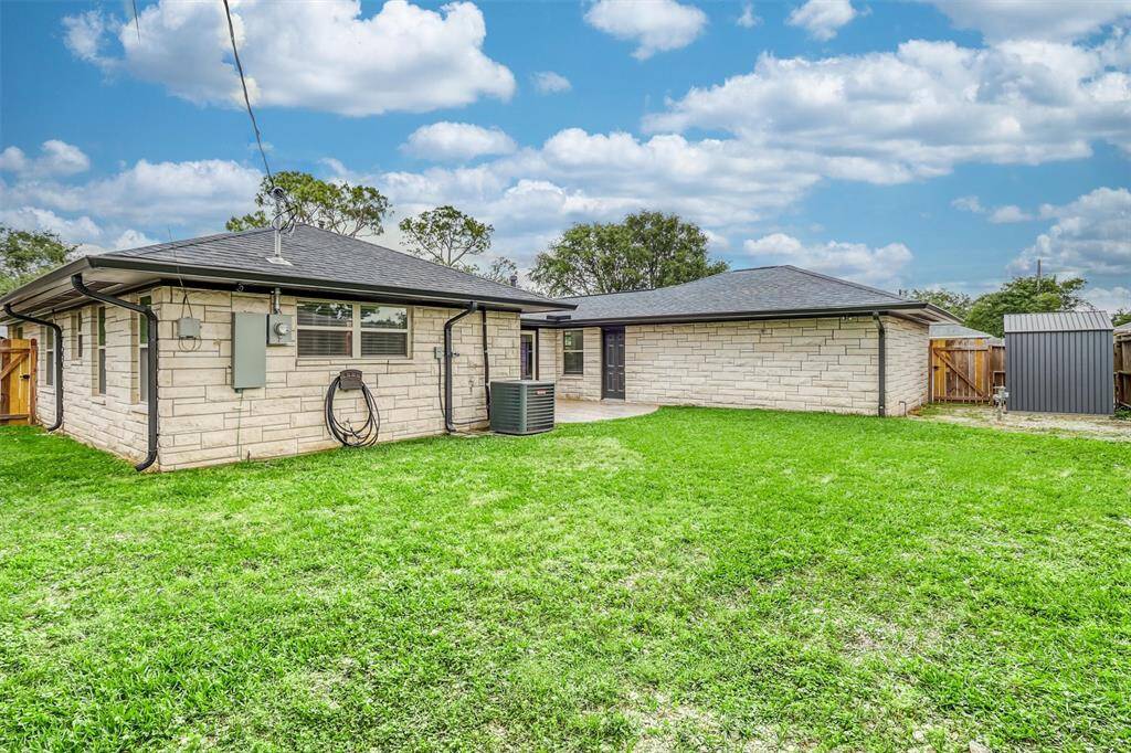 This expansive backyard features a large grassy area, patio space, and handy side shed—offering endless possibilities for use.