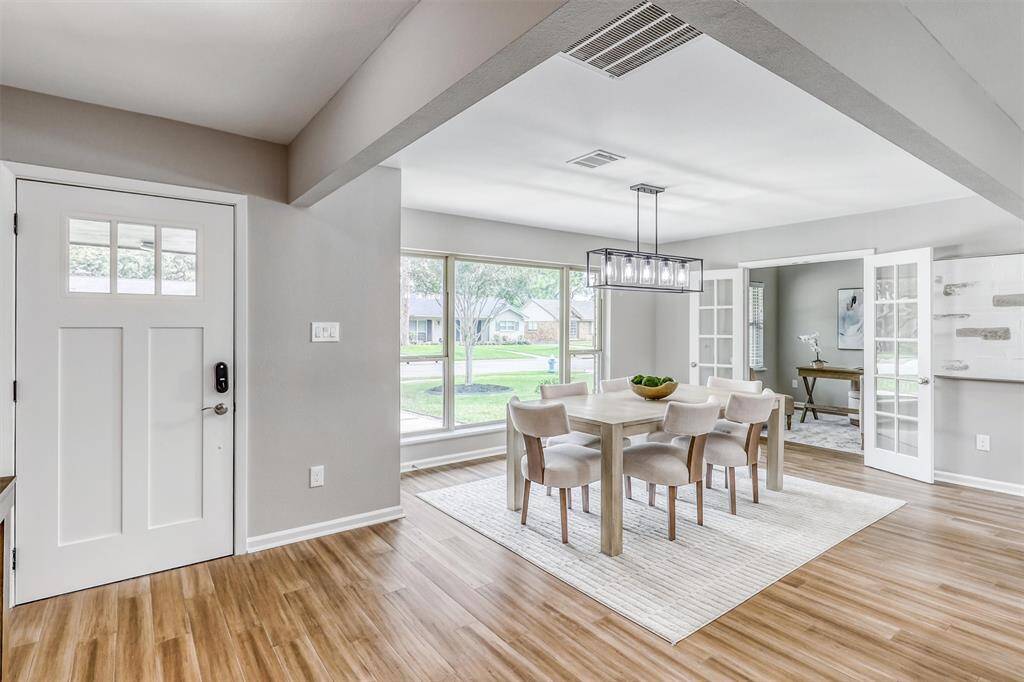 The foyer offers a cheerful first impression with engineered bamboo wood flooring, soft neutral tones, and sightlines that stretch into the open dining and living areas.