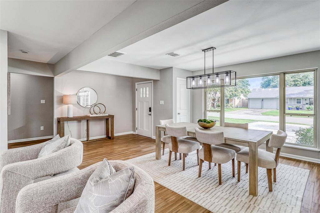 Oversized picture windows frame the formal dining room, flooding the space with natural light and offering a front-row view of the peaceful Lazybrook neighborhood.