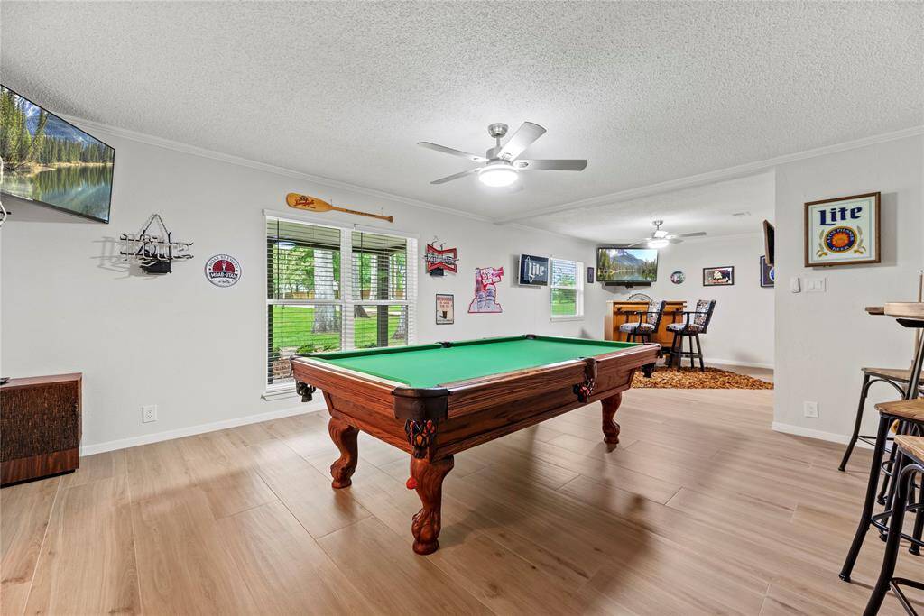 To the left of the entry, you'll find a versatile formal living space currently being used as an expansive game room. This room offers endless possibilities, whether you envision it as a sophisticated sitting area, a cozy reading nook, or an entertainment hub for family and friends.