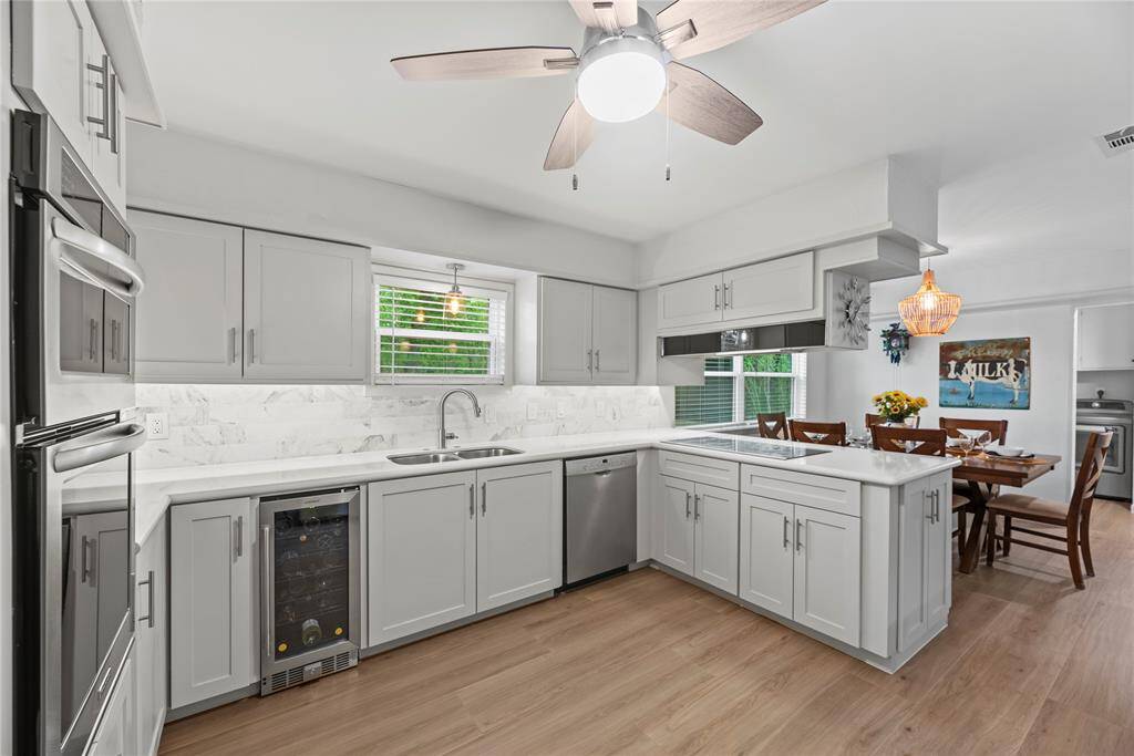 Crisp white cabinets with updated hardware provide a clean and timeless look, enhancing the sense of brightness and openness in this space.