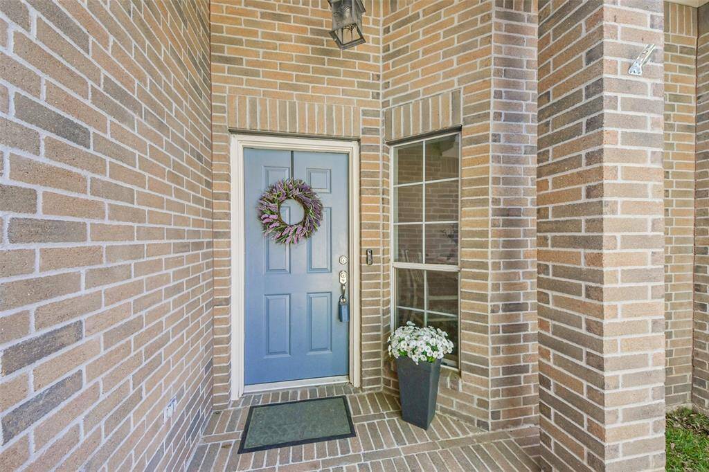 Covered Brick front patio to welcome you home