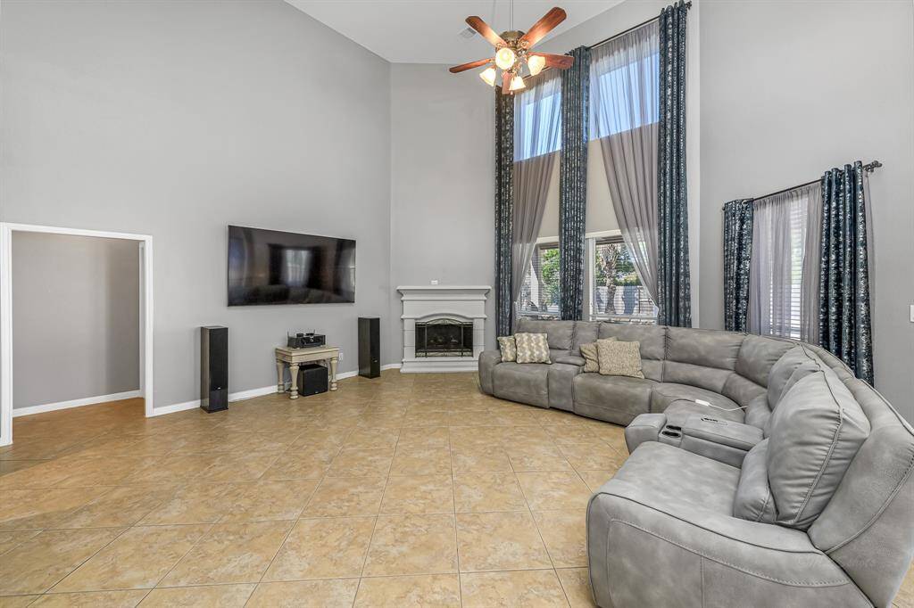 The family room exudes grandeur, blending architectural sophistication with inviting comfort, the gas log fireplace helps give this space a cozy feel