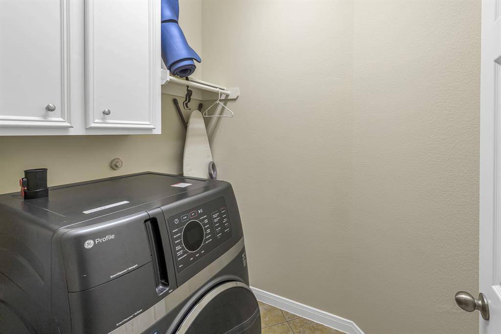 Laundry room has storage space and a bar to air dry your delicates