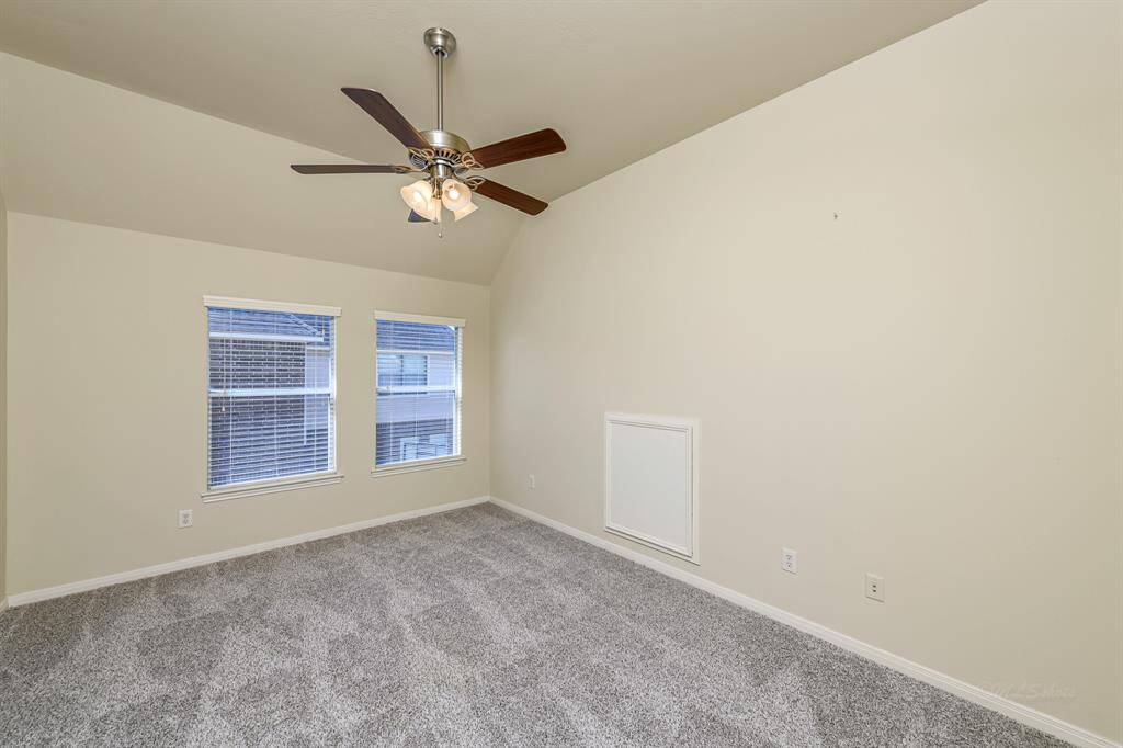 The 4th and final spacious bedroom with plush carpet and ceiling fan, with attic crawl space