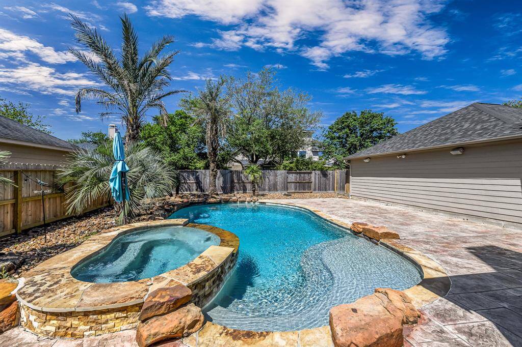 The beautiful palm trees add the the tropical feel of this amazing backyard