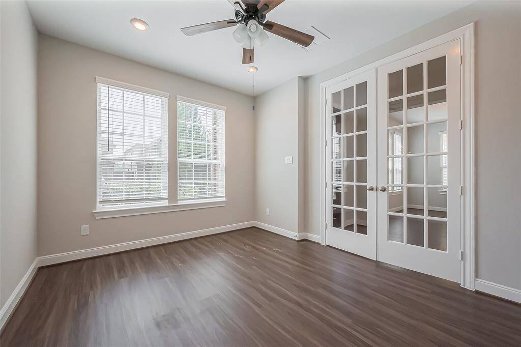 Defined by beautiful French doors, this room offers flexibility as a study, office, or creative space. Large windows brighten the area, while recessed lighting and a ceiling fan enhance both ambiance and comfort. Located to the right of the entryway, it serves as a quiet retreat within the home.