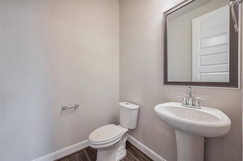 Sleek and simple, this well-placed half bath offers essential functionality with a clean design, making it perfect for guests.