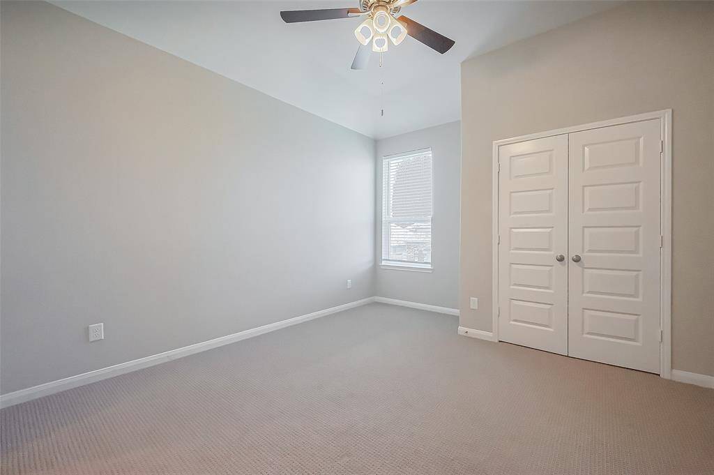 Spacious and well-appointed, this bedroom features plush carpeting, a ceiling fan, and a large window for natural light. A private en suite adds convenience, making it an ideal personal space.