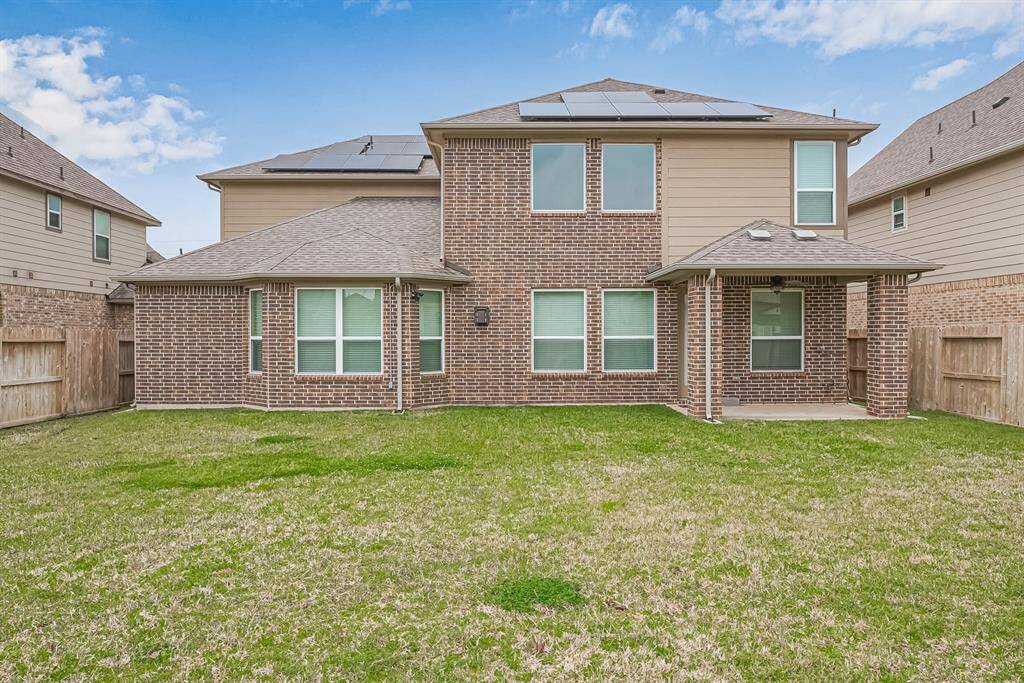 The covered patio extends the living space outdoors, providing a comfortable spot to relax while taking in the scenic view of the backyard.