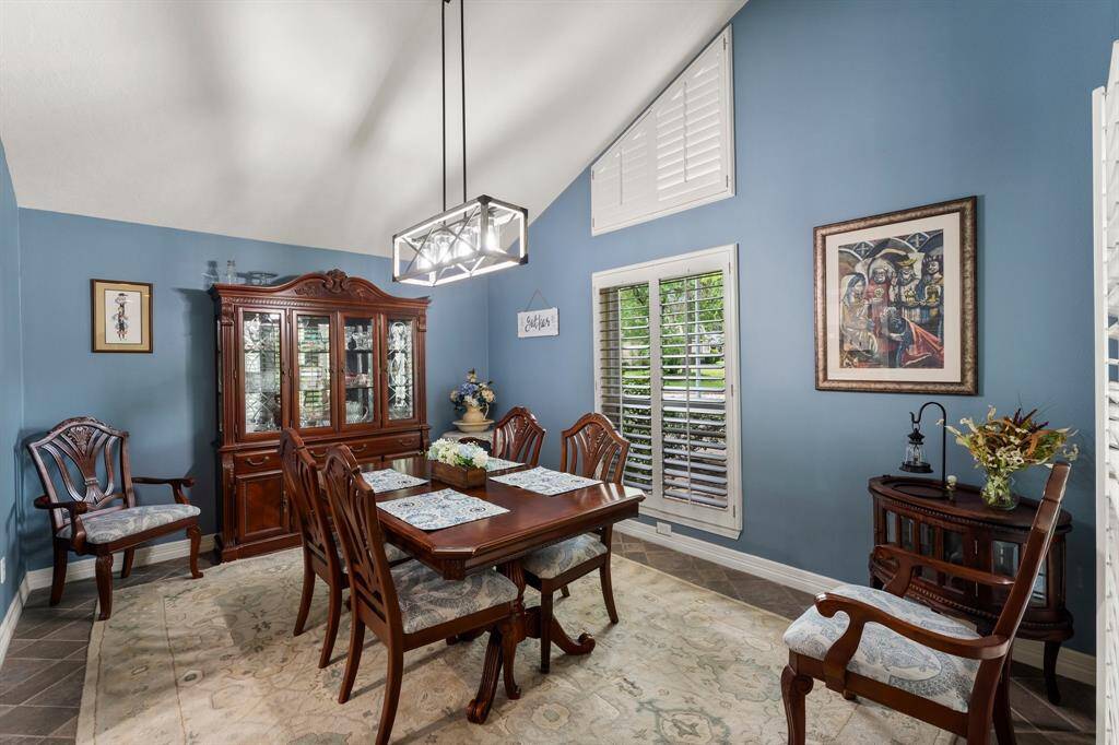 This inviting dining room offers a blend of comfort and style. The tasteful decor, including the elegant china cabinet and artwork, enhances the dining experience.