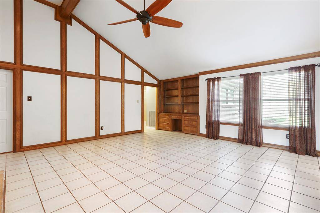 Large living area with vaulted ceilings and desk for maximum use of space. (Curtains have been removed.)