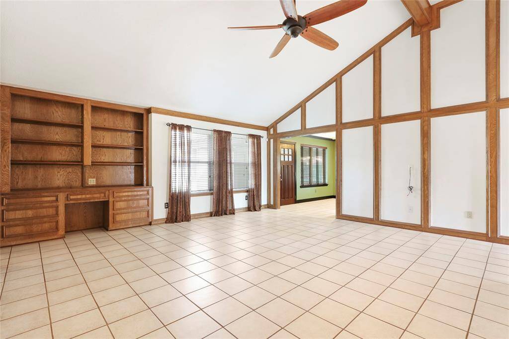 View of living area leading to backdoor. (Curtains have been removed.)