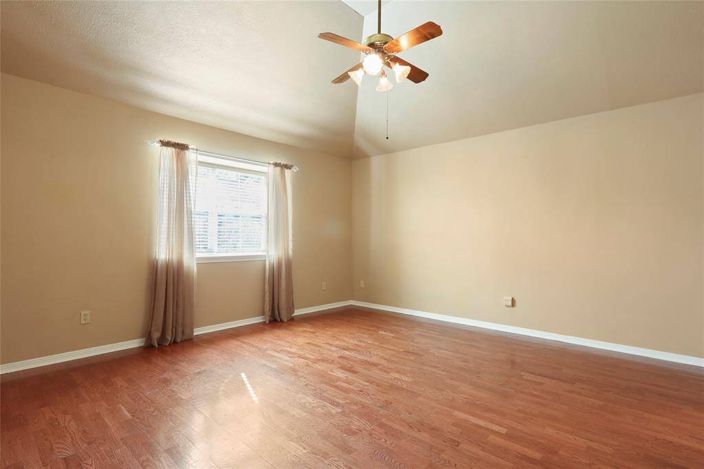 Primary bedroom. (Ceiling fan and lights have been updated after this picture was taken and curtains have been removed.)