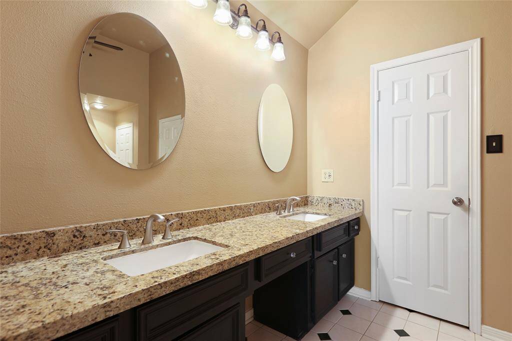 Primary bathroom with granite countertops and double sinks.