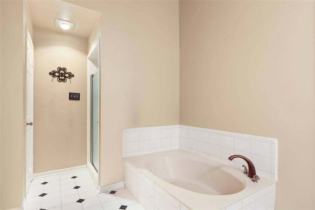 The primary bathroom features a soaking tub and a separate walk-in shower.