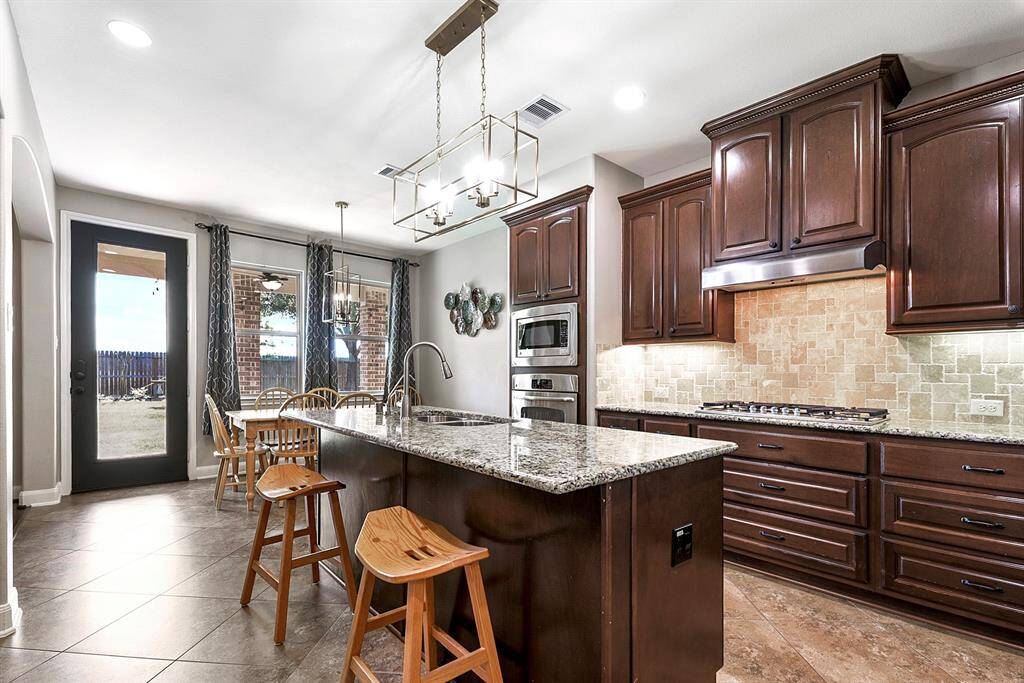 The large kitchen shows off beautiful granite countertops with endless counter space, complemented by plenty of cabinets and drawers to meet all your storage needs. A convenient breakfast bar offers additional seating. Throughout the home, you’ll notice upgraded chandeliers and pendant lighting that tie together the elegant design and add a touch cohesiveness of to every room.