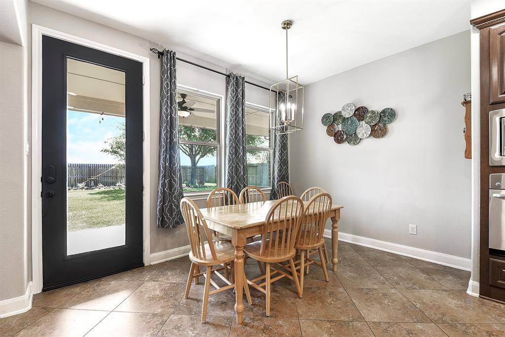 The spacious breakfast bar offers plenty of room for a large dining table, easily accommodating up to six people. The area features beautiful backyard views and provides easy access to the backyard, making it perfect for hosting barbecues and outdoor gatherings.