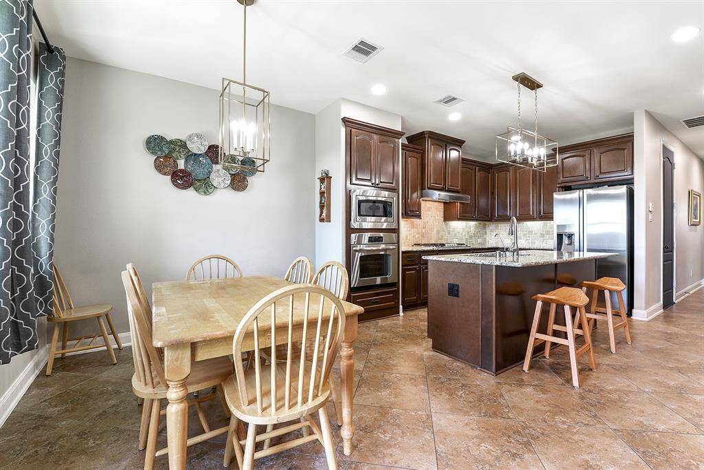 From the back door, you’re greeted with a view of the spacious kitchen and breakfast room, where the matching chandeliers tie in beautifully with the elegant light fixture in the formal dining room, creating a cohesive and stylish flow throughout the home.