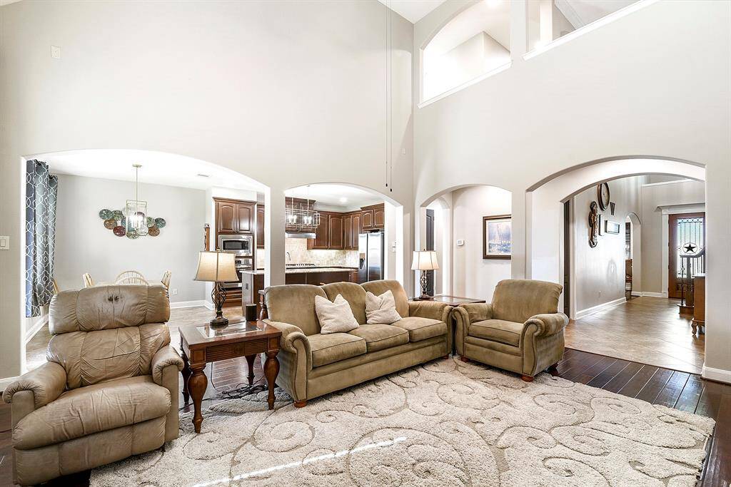 From the living room, you can appreciate the open flow of the home, which seamlessly connects to the kitchen, extends to the front door, and leads upstairs, enhancing the sense of space and connectivity throughout the home.