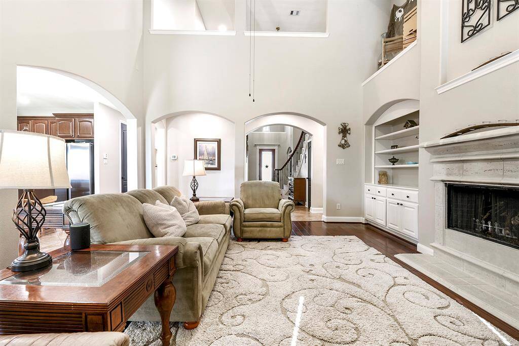 The expansive living room offers plenty of storage space with built-in cabinetry and dual display nooks on each side of the gas stone-cast fireplace, providing both functionality and a stylish focal point for the room.