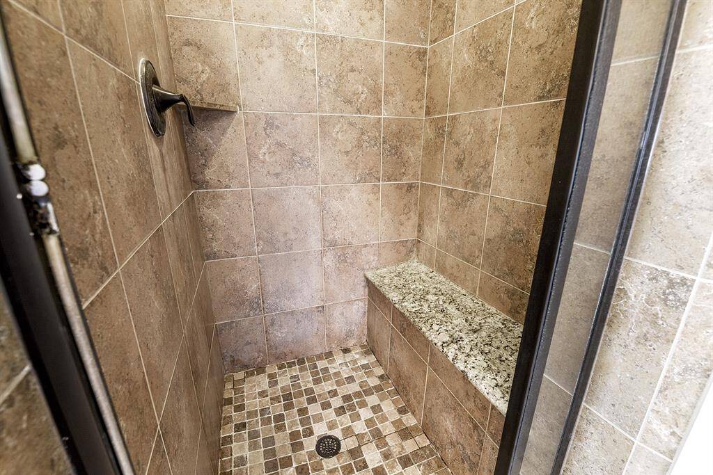 This luxurious walk-in shower features a built-in bench, seating area, and shampoo shelving, providing both comfort and convenience for your daily routine.