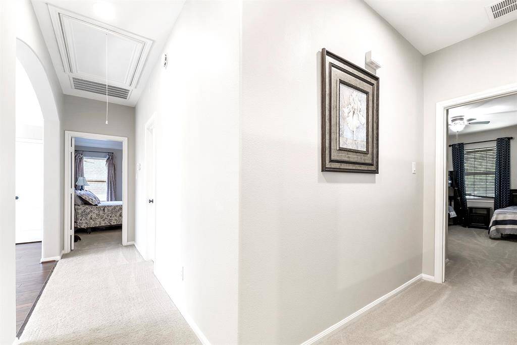 One side of the home features two generously sized guest bedrooms that share a Hollywood-style bathroom. Each bedroom has its own private vanity and sink