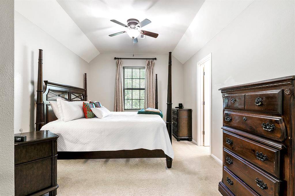 The home offers a total of four spacious bedrooms, each featuring large walk-in closets. This particular bedroom provides plenty of room for a king-sized bedroom suite and includes an attached bathroom, offering both comfort and privacy.