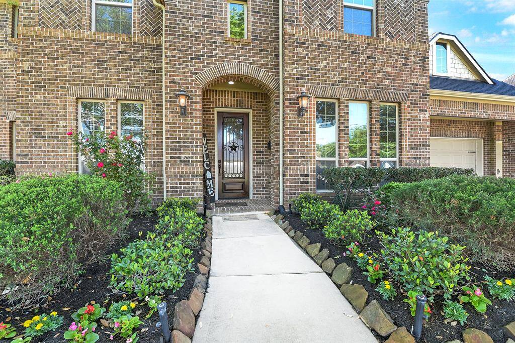 Beautifully landscaped front yard with a sidewalk leading to your covered front entry, featuring a striking solid wood door with an iron Texas Star design. The home showcases full brick construction on all sides, for a timeless curb appeal.