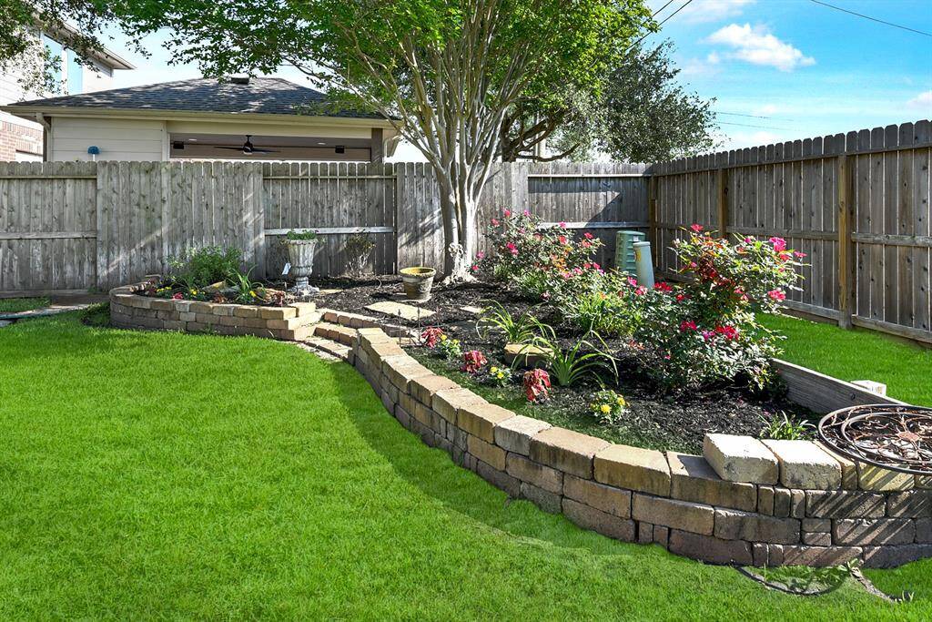The current owner has a garden bed tucked in the corner, creating a beautiful landscape that adds charm and a touch of nature to the backyard.