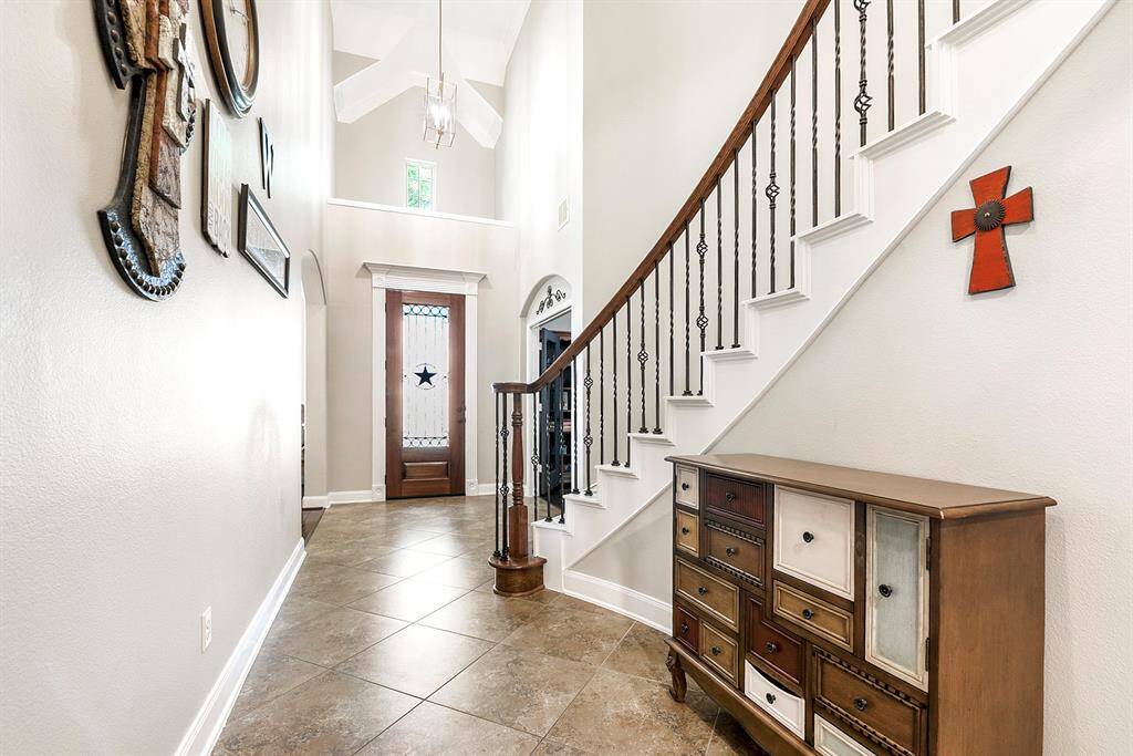 From the wide two-story foyer, facing the front door, you’ll find French doors on the right leading into the private home office, while directly across is the formal dining room. Both spaces offer beautiful views of the landscaped front yard, filling the rooms with natural light and creating a warm, inviting atmosphere.
