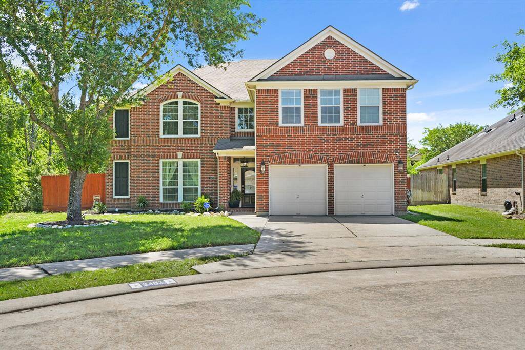 The beautifully maintained front yard features a mature shade tree, vibrant landscaping, and convenient in-ground sprinkler system.